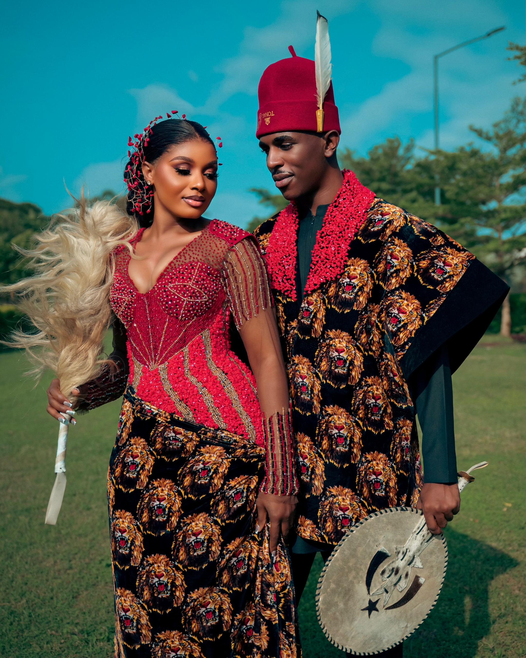 Couple embracing in crimson and isiagu traditional bridal wear